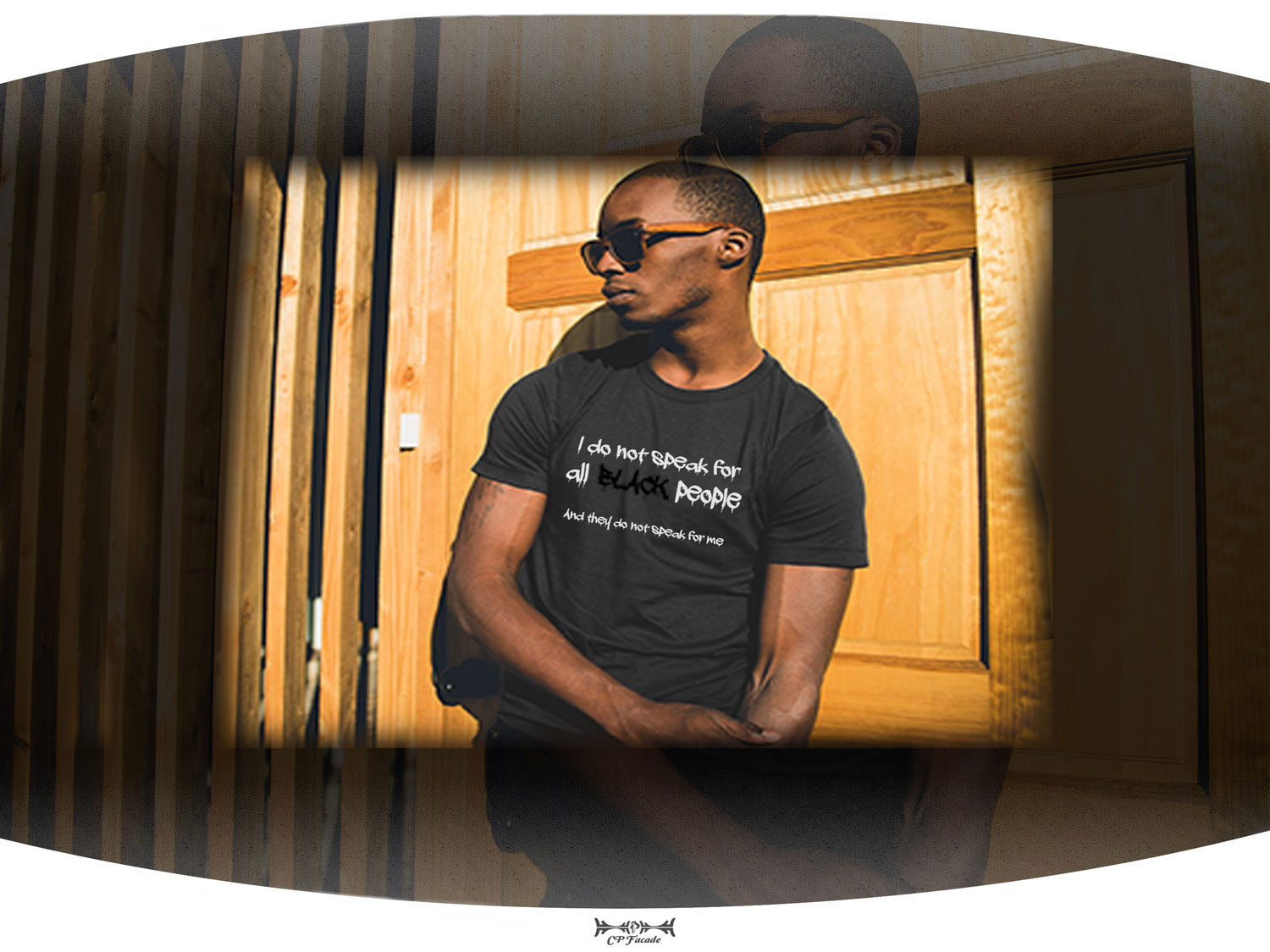 Black man wearing shades leaning on wall wearing dark grey t-shirt with the phrase I do not speak for all black people on the front of it